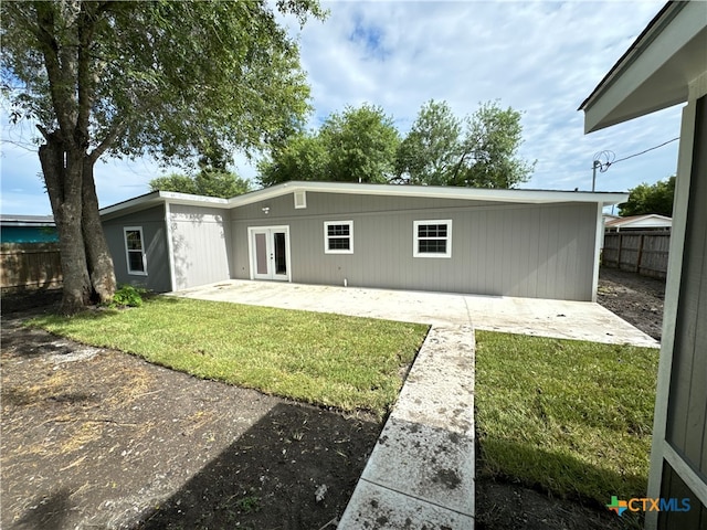 rear view of property featuring a lawn and a patio