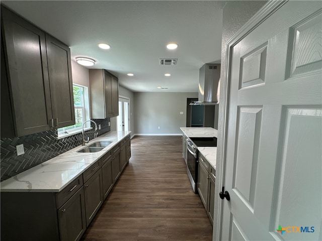 kitchen with sink, wall chimney exhaust hood, stainless steel range with electric stovetop, backsplash, and dark hardwood / wood-style flooring