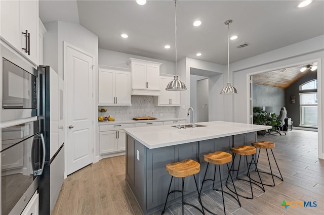 343 Sugarcane, New Braunfels, TX 78132 - kitchen featuring white cabinets, light wood-style floors, a kitchen bar, and a sink