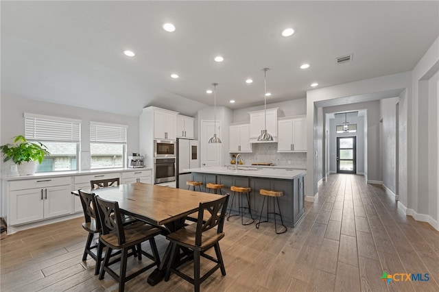 343 Sugarcane, New Braunfels, TX 78132 - dining room featuring recessed lighting, lofted ceiling, visible vents, light wood-style floors, and baseboards