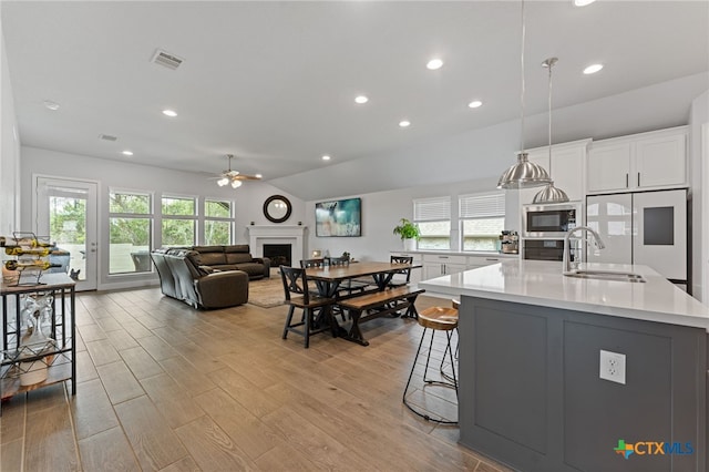 343 Sugarcane, New Braunfels, TX 78132 - kitchen featuring a sink, stainless steel microwave, a ceiling fan, a fireplace, and refrigerator