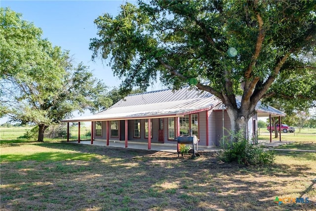 back of house with a patio area and a lawn