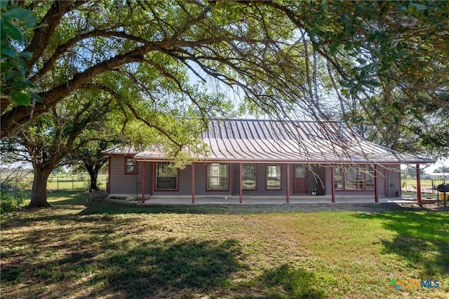 rear view of property with a lawn and a patio