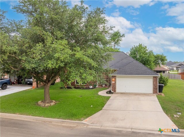 2627 Butterfly Dr, Temple, TX 76502 - view of front facade with brick siding, a front lawn, concrete driveway, roof with shingles, and an attached garage