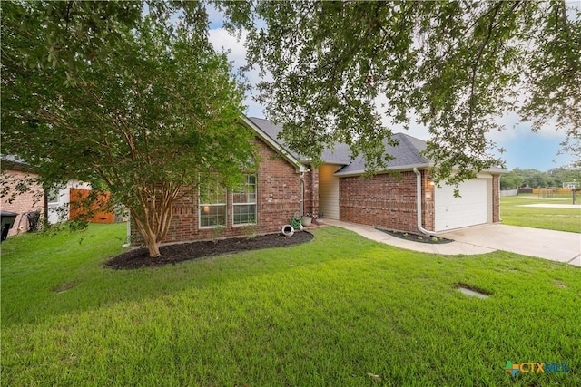 2627 Butterfly Dr, Temple, TX 76502 - obstructed view of property with concrete driveway, brick siding, a front lawn, and a garage