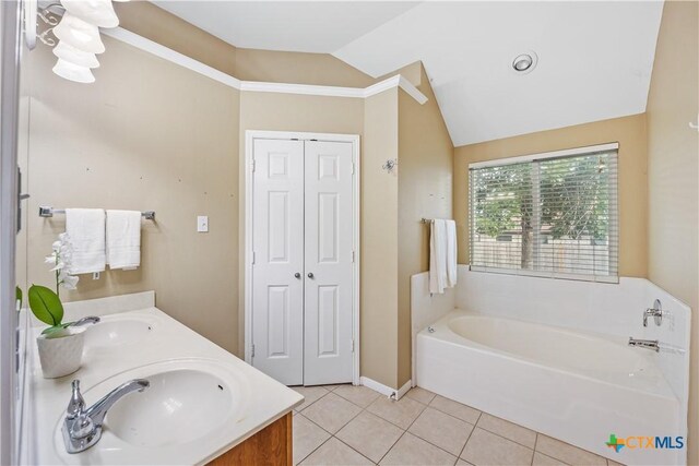 2627 Butterfly Dr, Temple, TX 76502 - bathroom with vaulted ceiling, a garden tub, tile patterned flooring, double vanity, and baseboards