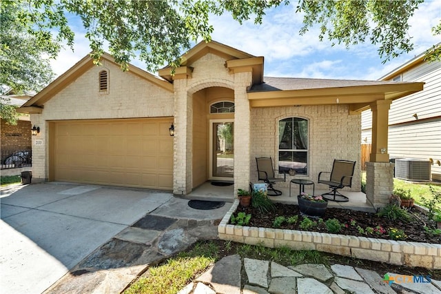 view of front of home with covered porch, cooling unit, and a garage