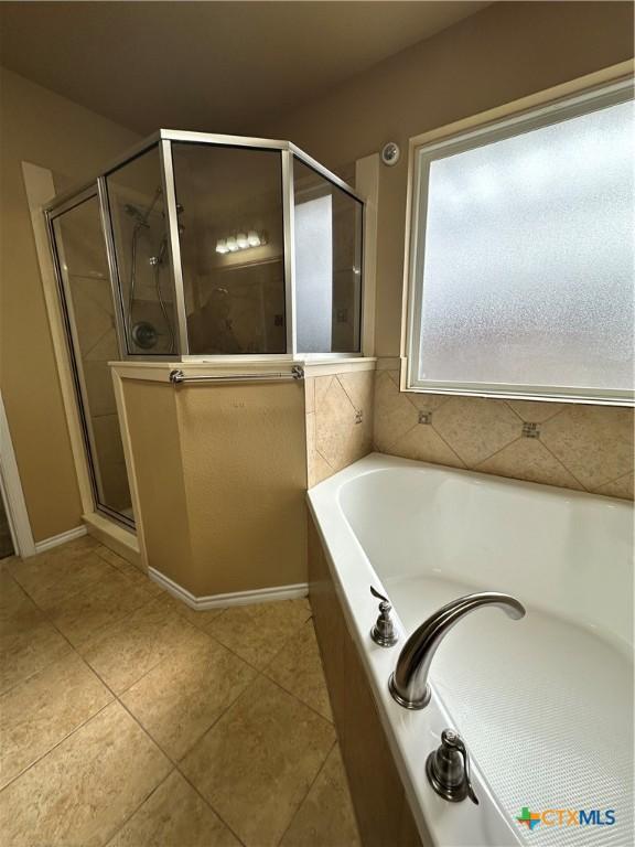 full bathroom with a stall shower, a garden tub, and tile patterned floors