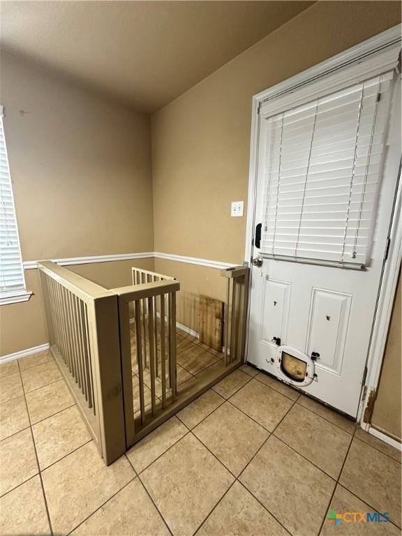 interior space with light tile patterned flooring and an upstairs landing