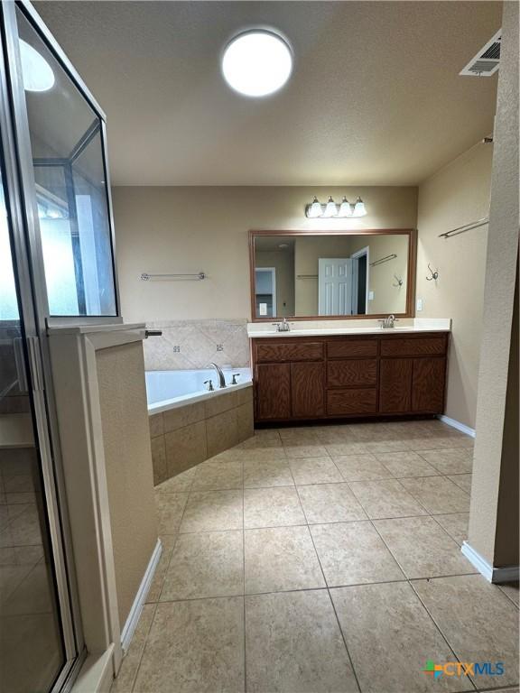 full bathroom with tile patterned floors, visible vents, a sink, and a bath