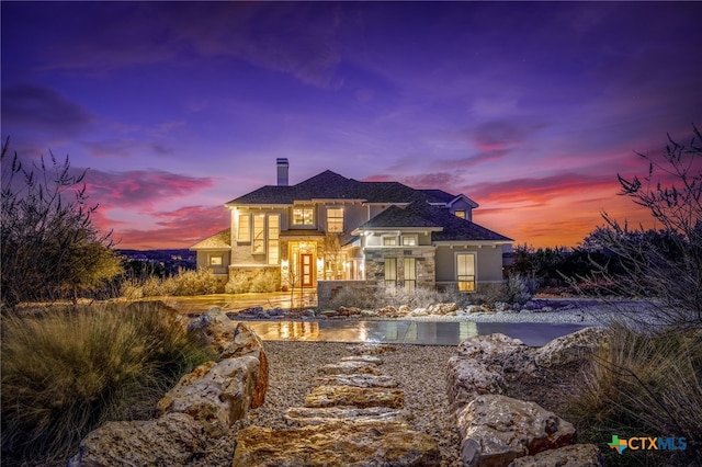 mediterranean / spanish-style home with stone siding and a chimney