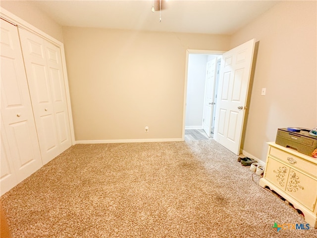 unfurnished bedroom featuring carpet flooring and a closet