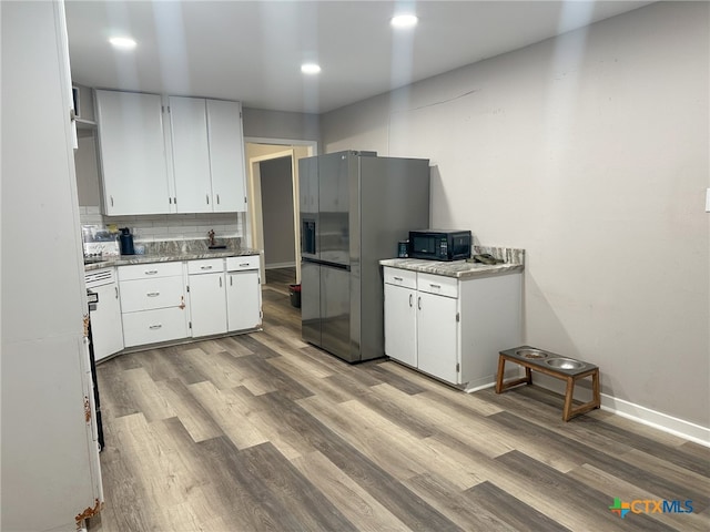 kitchen with stainless steel fridge with ice dispenser, white cabinetry, tasteful backsplash, and light hardwood / wood-style floors