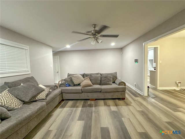 living room featuring ceiling fan and light hardwood / wood-style flooring