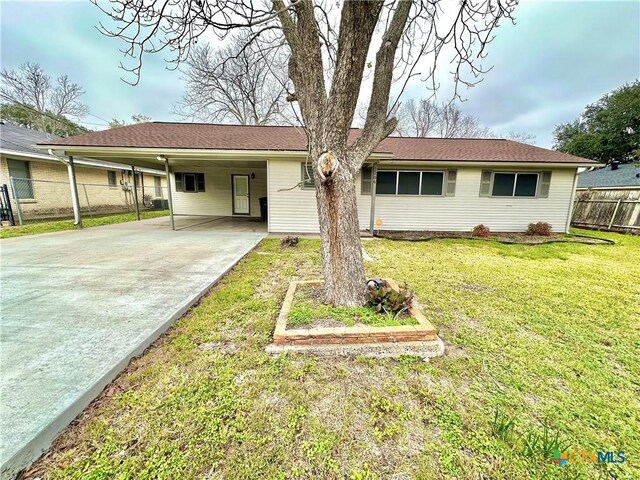 ranch-style home featuring a carport and a front lawn