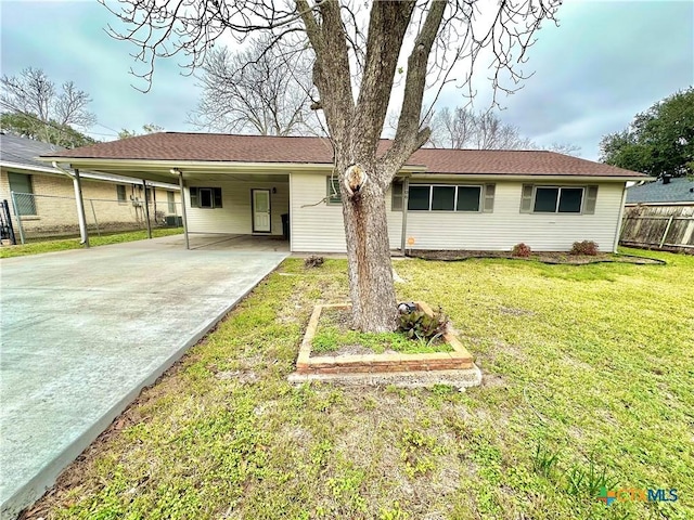 view of front of property with concrete driveway, fence, a carport, and a front yard