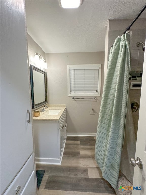 bathroom with vanity, hardwood / wood-style flooring, and curtained shower