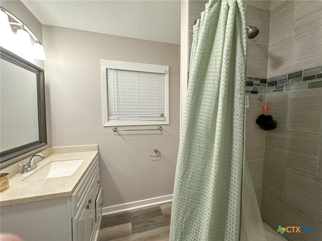 bathroom with curtained shower, vanity, and wood-type flooring