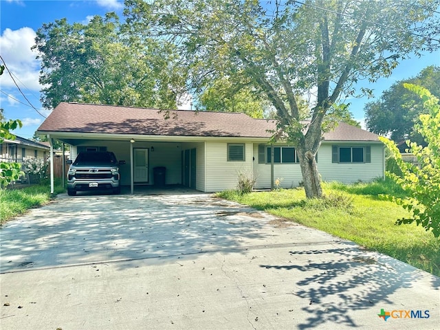 ranch-style home with a carport, driveway, and fence