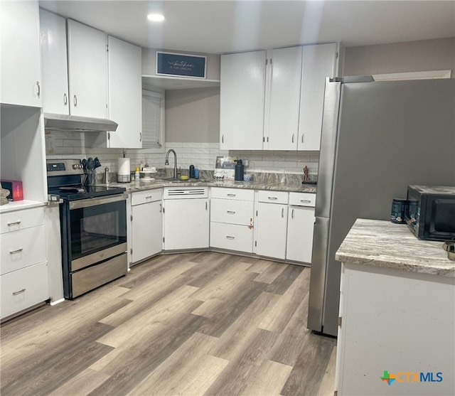 kitchen with electric range, light wood-type flooring, white cabinetry, and tasteful backsplash