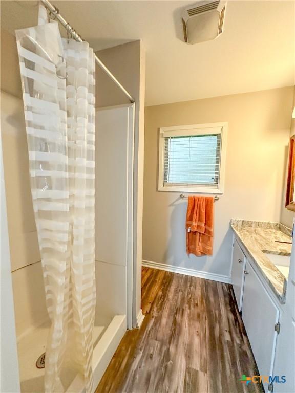 clothes washing area featuring wood-type flooring and washer and clothes dryer