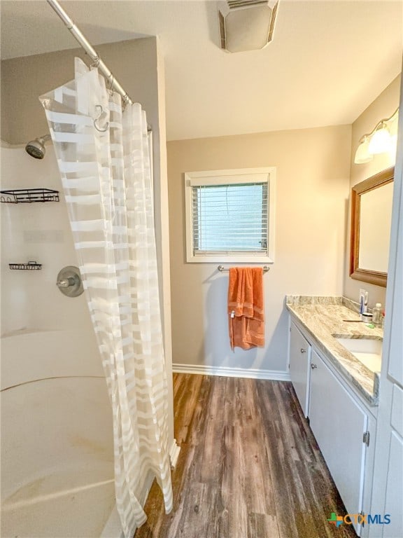 bathroom with wood-type flooring, vanity, and walk in shower