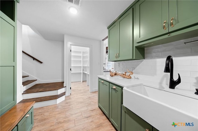 2037 Heritage Loop, Nolanville, TX 76559 - kitchen with green cabinetry, backsplash, light wood-type flooring, and light countertops