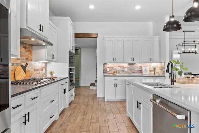 2037 Heritage Loop, Nolanville, TX 76559 - kitchen featuring appliances with stainless steel finishes, decorative backsplash, under cabinet range hood, white cabinets, and decorative light fixtures