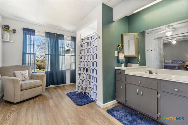 bathroom with baseboards, a ceiling fan, wood finished floors, curtained shower, and vanity