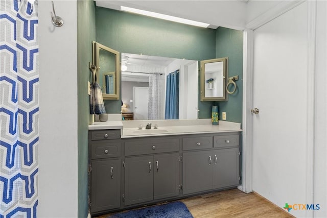 full bathroom featuring wood finished floors and vanity