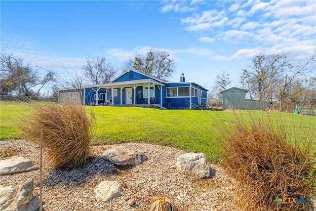 view of front of home with a storage unit, a front lawn, a porch, and an outdoor structure