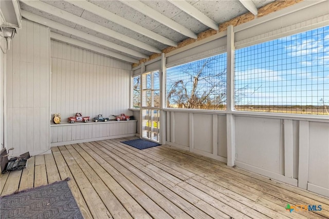 unfurnished sunroom with vaulted ceiling with beams