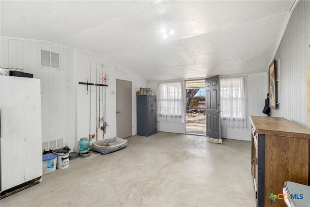 basement with freestanding refrigerator and visible vents