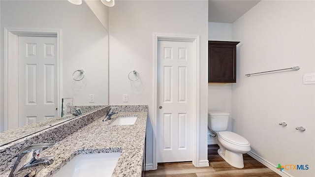 bathroom featuring hardwood / wood-style flooring, vanity, and toilet