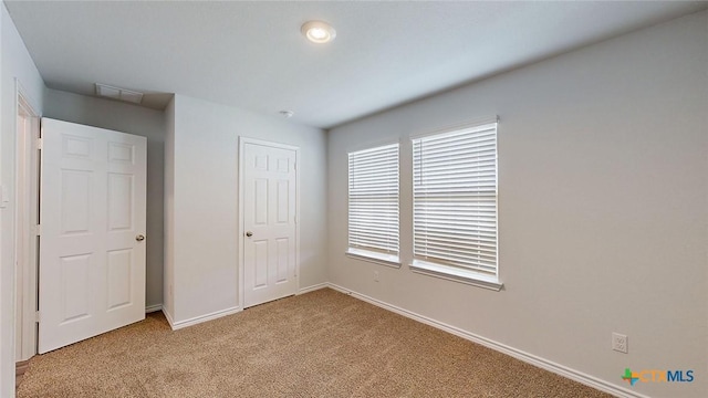 unfurnished bedroom featuring light carpet