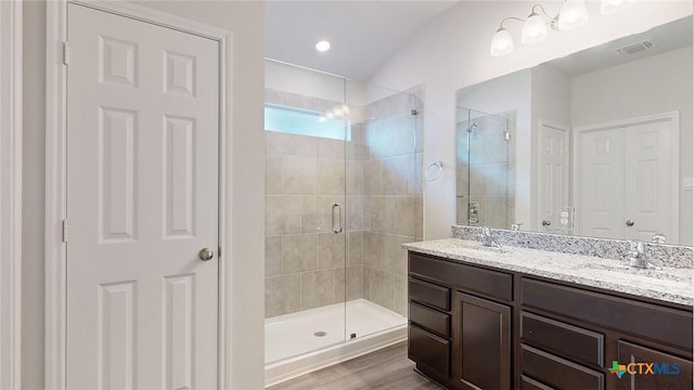 bathroom featuring hardwood / wood-style flooring, vanity, and a shower with door