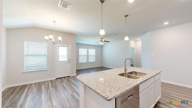 kitchen with dishwasher, an island with sink, sink, white cabinets, and light stone countertops