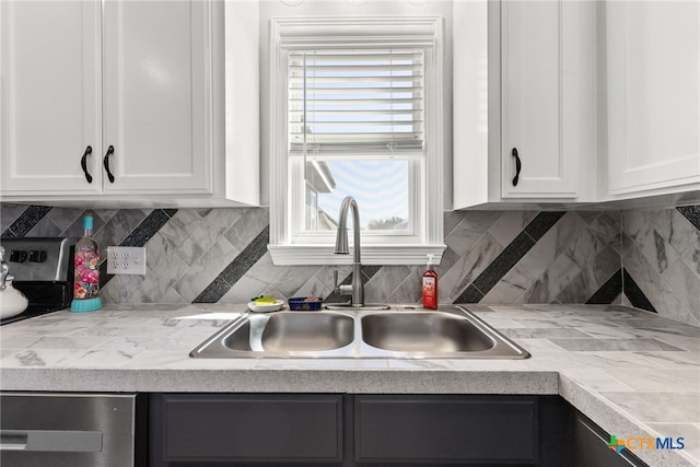 kitchen featuring white cabinets, sink, and tasteful backsplash