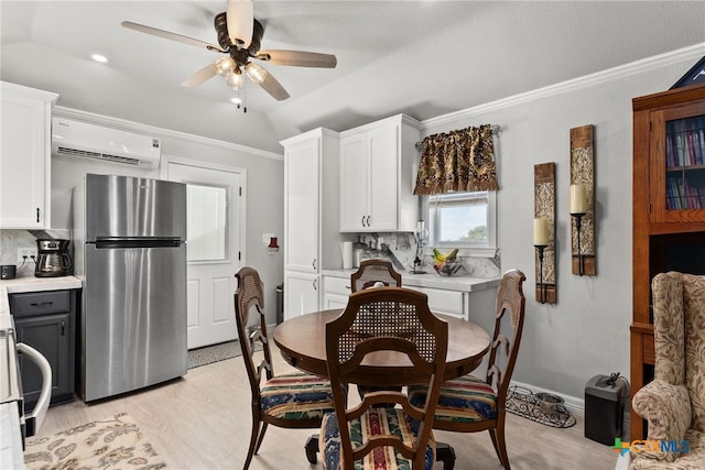 dining area with vaulted ceiling, ornamental molding, ceiling fan, light hardwood / wood-style flooring, and a wall mounted air conditioner