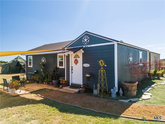 exterior space with a front yard and a patio area