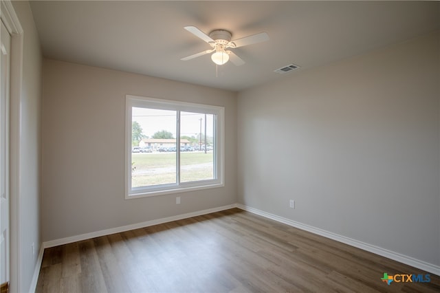 empty room with ceiling fan and light hardwood / wood-style flooring