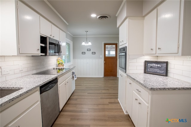 kitchen featuring pendant lighting, white cabinetry, stainless steel appliances, ornamental molding, and a chandelier