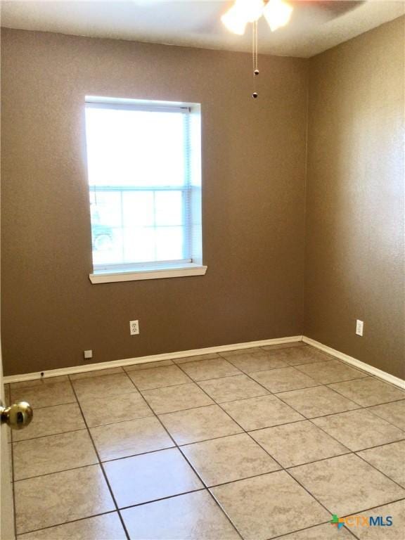 empty room featuring tile patterned flooring and ceiling fan