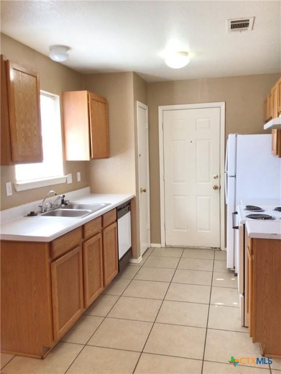 kitchen featuring sink, white appliances, and light tile patterned flooring