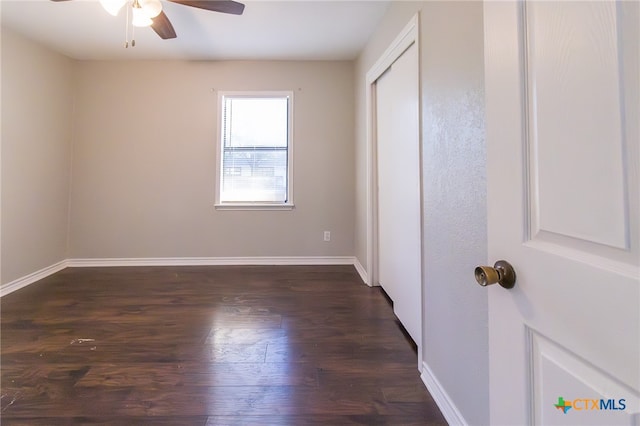 unfurnished bedroom with ceiling fan and dark hardwood / wood-style flooring