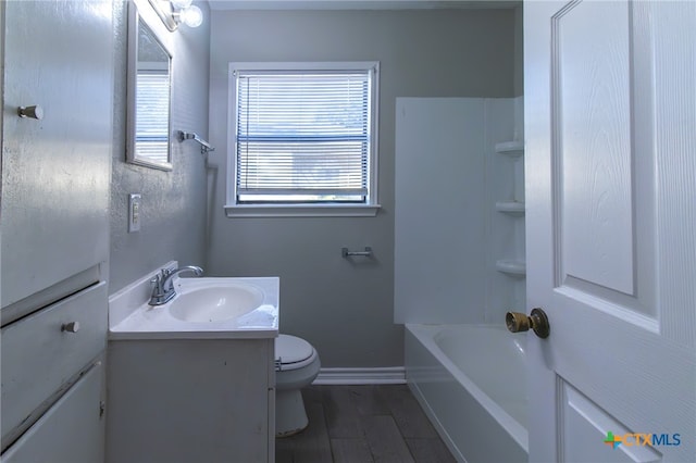 bathroom with toilet, vanity, and wood-type flooring