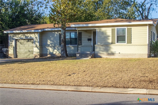 ranch-style house with covered porch, a garage, and a front lawn