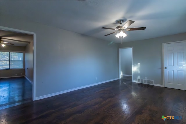 spare room featuring dark wood-type flooring and ceiling fan