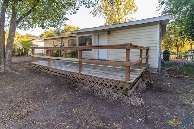 rear view of property featuring a wooden deck