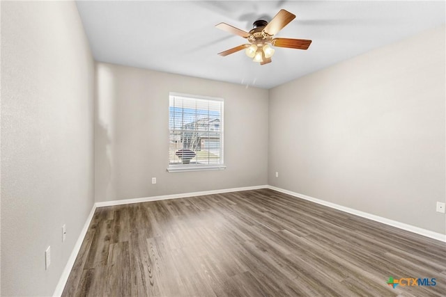 unfurnished room with ceiling fan, baseboards, and wood finished floors